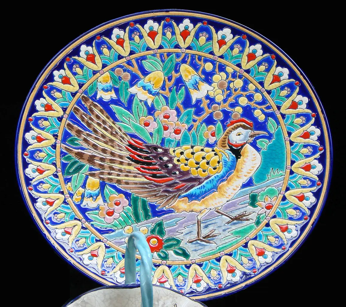 Assiette décorative avec motif de paon coloré.